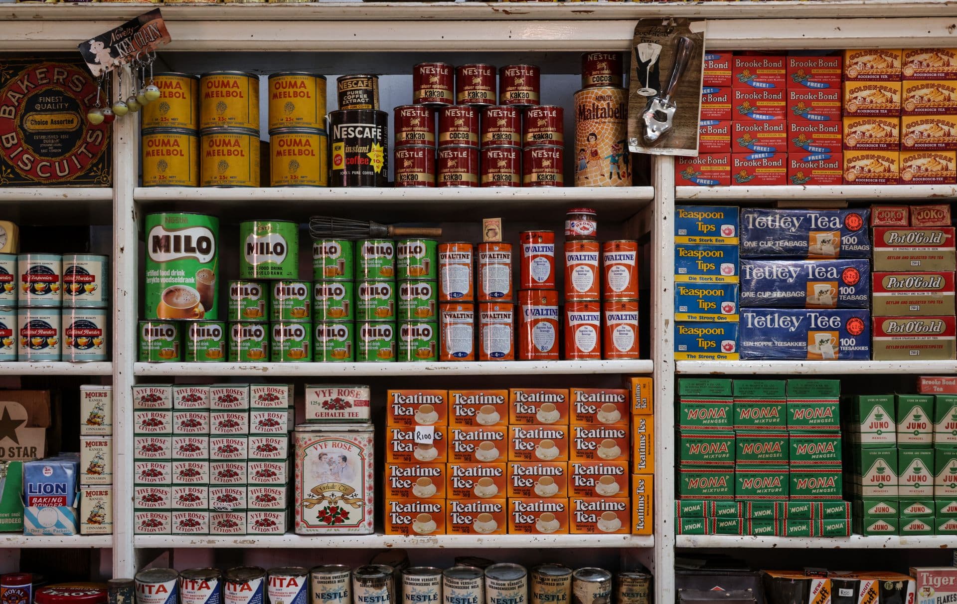 A nostalgic view of vintage grocery store shelves filled with assorted food products and drinks.