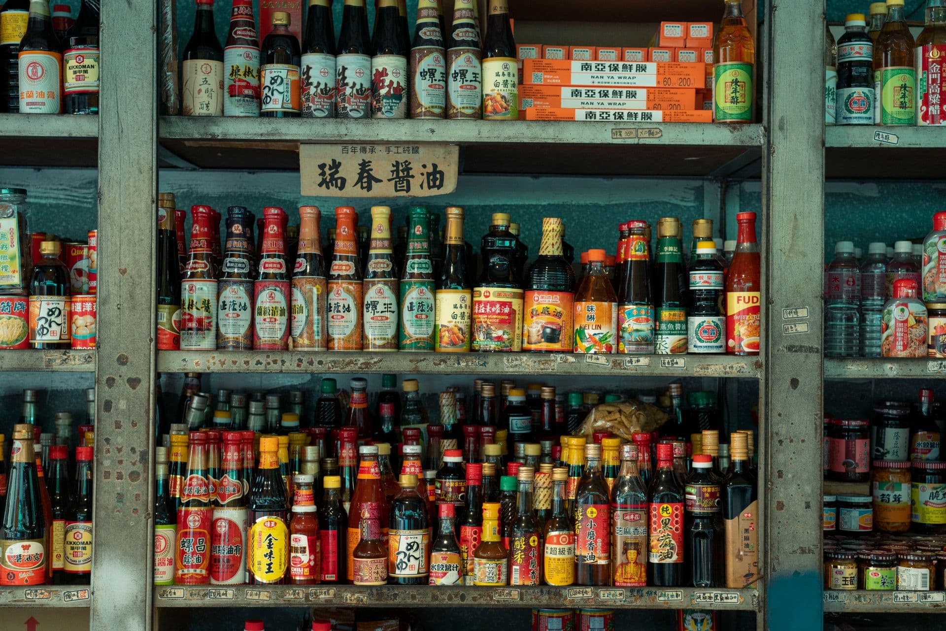 Colorful display of Asian sauces and condiments on market shelves in New Taipei City, Taiwan.